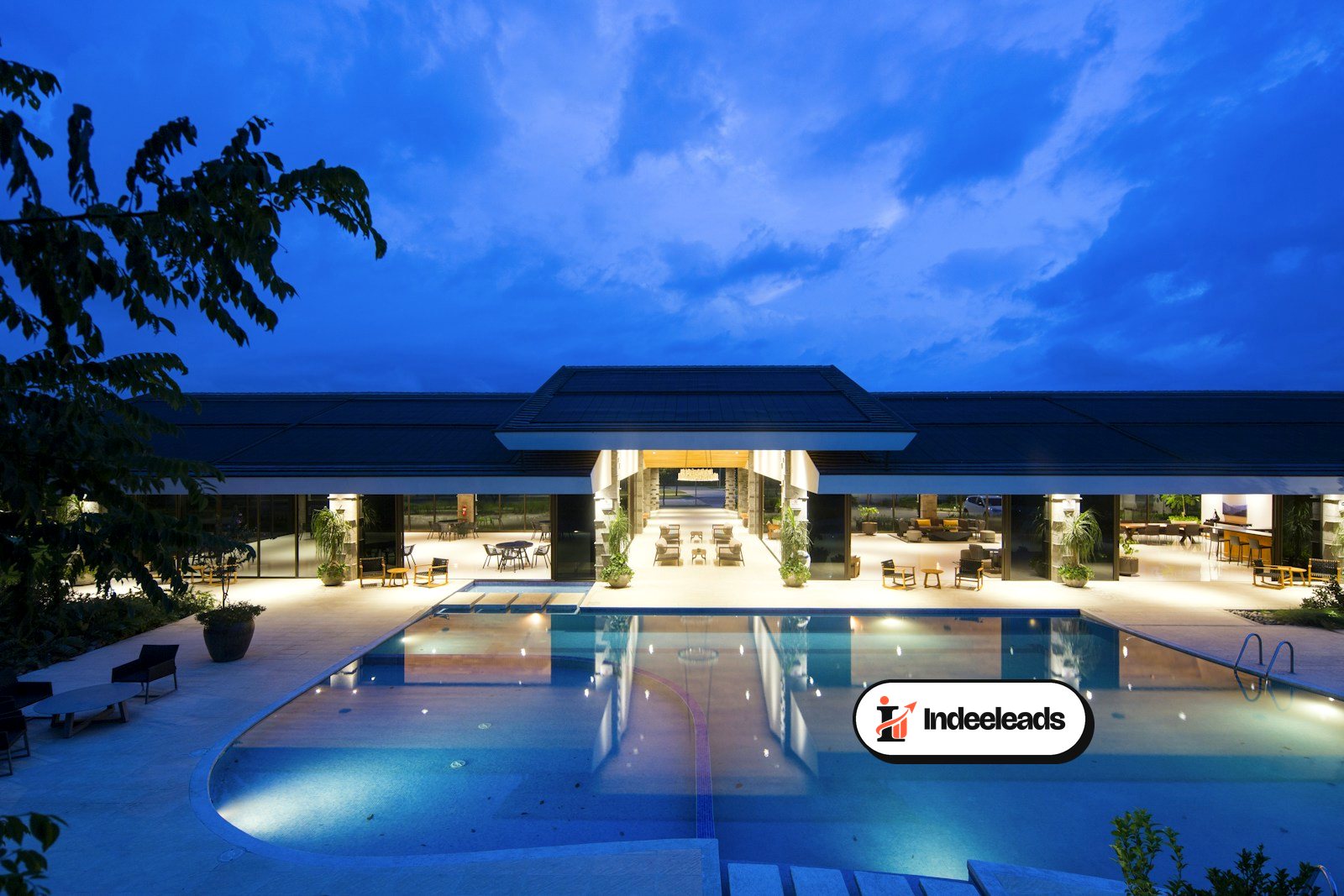 Hotel entrance and swimming pool lit up at dusk