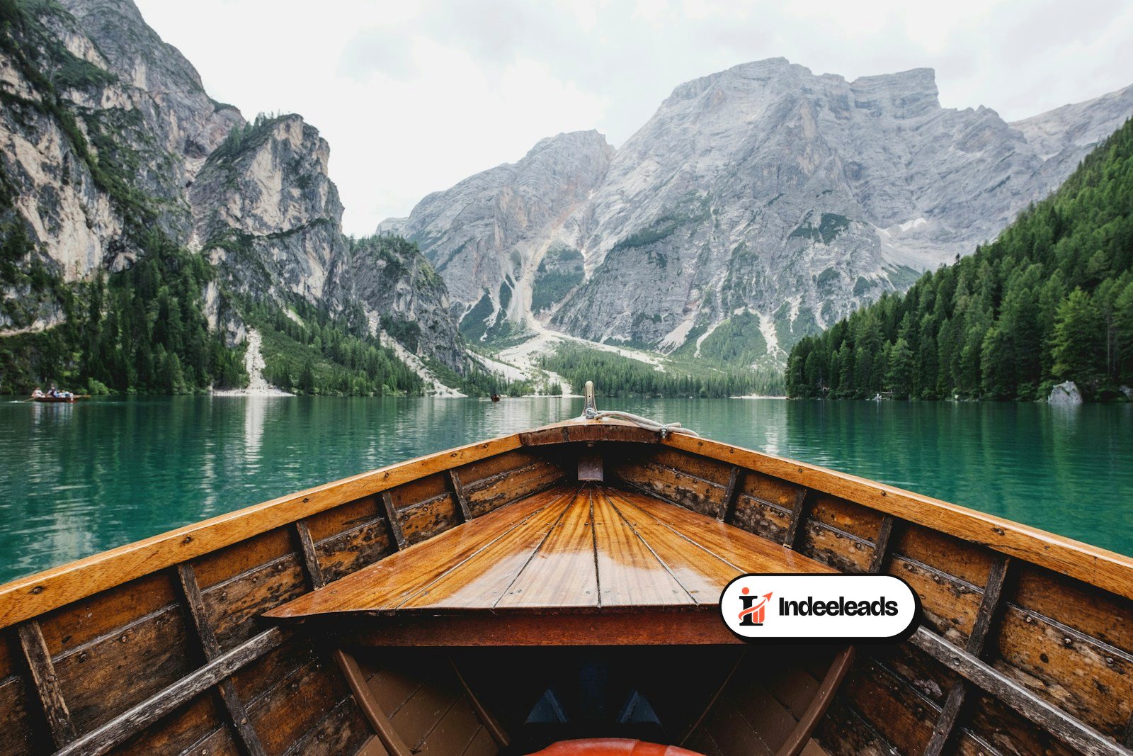 Boat on a turquoise mountain lake surrounded by peaks